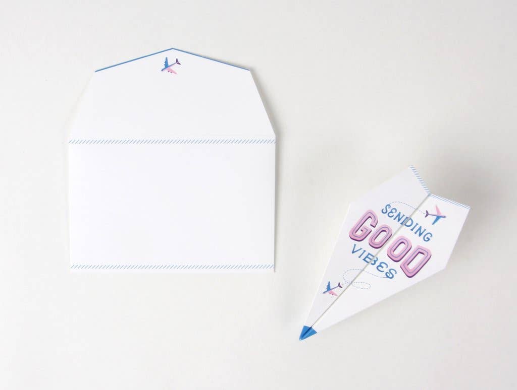 Paper Airplane Pop-Up Card with 'Sending Good Vibes' message next to white envelope, available at stationery store.