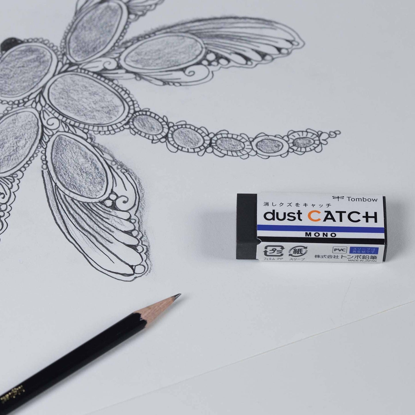 MONO Dust Catch Eraser by Tombow next to technical drawing and pencil, perfect for stationery store use, prevents eraser residue damage.