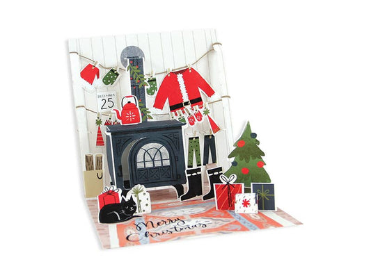 Cozy Christmas Pop-Up Card with festive fireplace scene, glitter, and string. Perfect holiday greeting from your favorite stationery store.