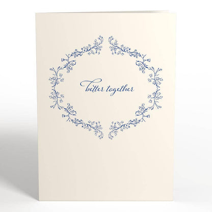 Better Together Mr & Mrs 5x7 pop-up wedding card with floral wreath design, available at stationery store. Ideal for weddings or home decor.