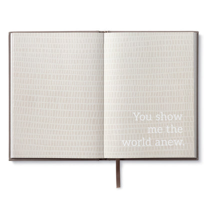 Alt Tag: Open book titled 'In This Moment' with text 'You show me the world anew' available at stationery store