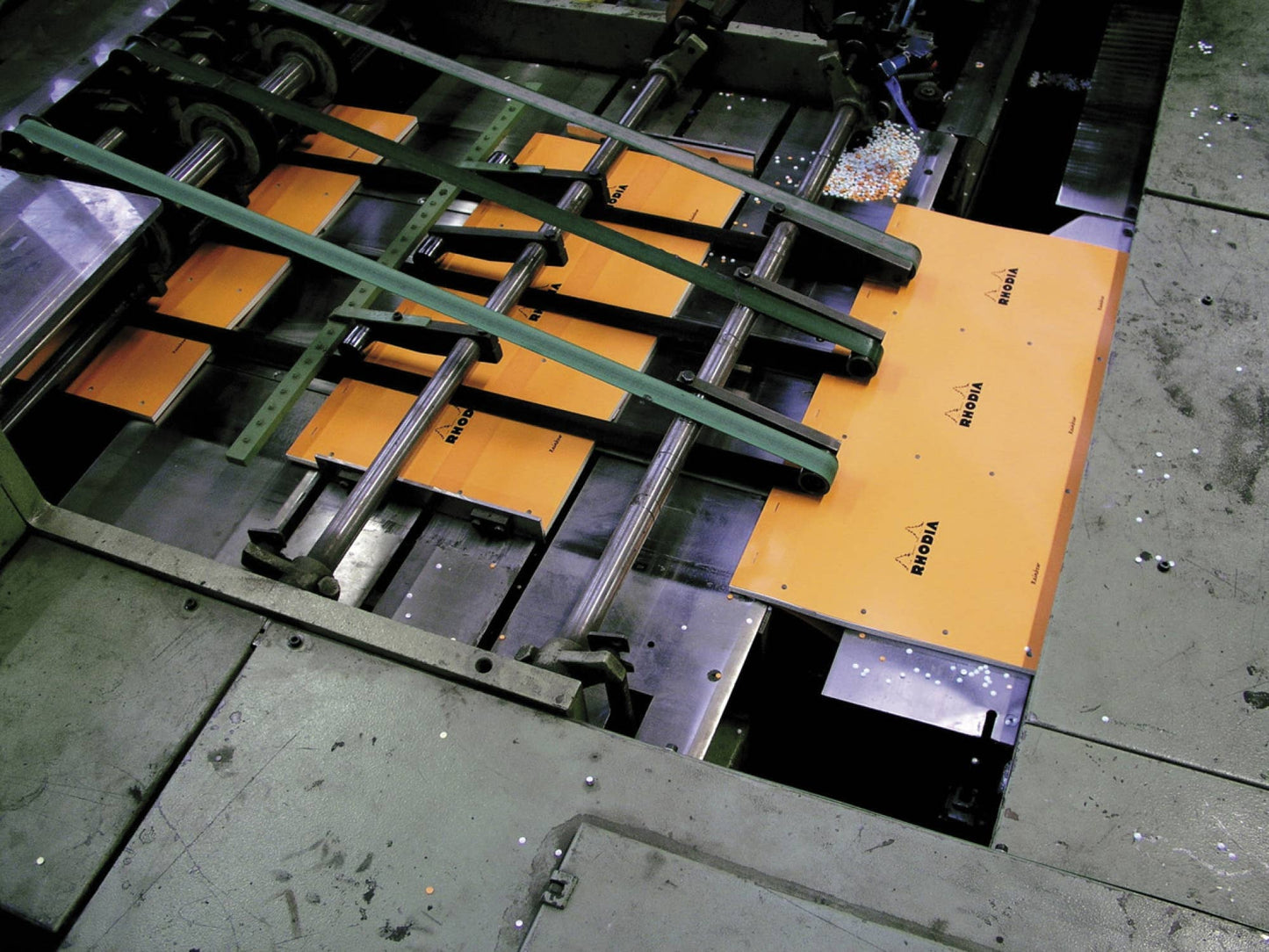 Rhodia Classic Notepad production on assembly line; orange covers ready for binding. Smooth paper ideal for stationery store collection.