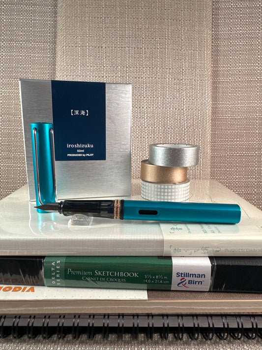 LAMY AL-star Fountain Pen with ink, notebooks, and stationery supplies in a stationery store setting.