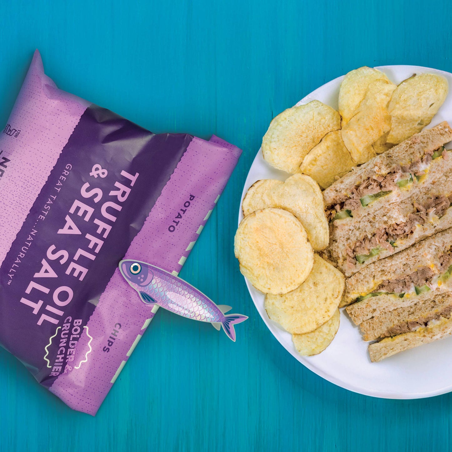 Truffle sea salt chips clipped with Fish 'N Clips sardine bag clip next to sandwich and chips on plate.