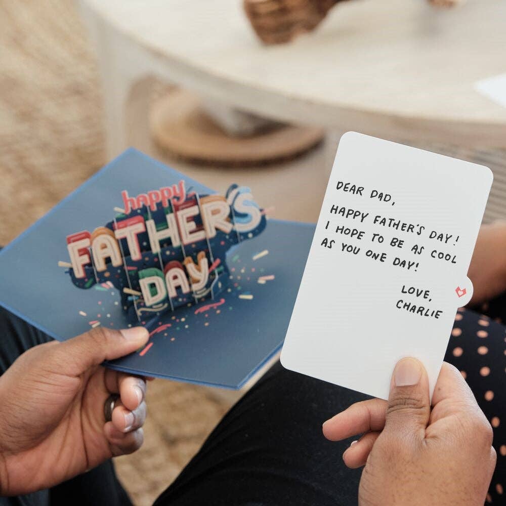 Man holding pop-up Father's Day card with colorful 3D design, note inside reads 'Dear Dad, happy Father's Day!' Perfect for stationery store gifting.