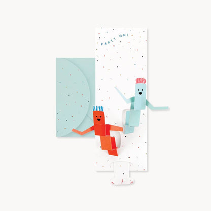 Totally Tubular pop-up greeting card with pull-tab, featuring colorful dancing figures, available at stationery store.