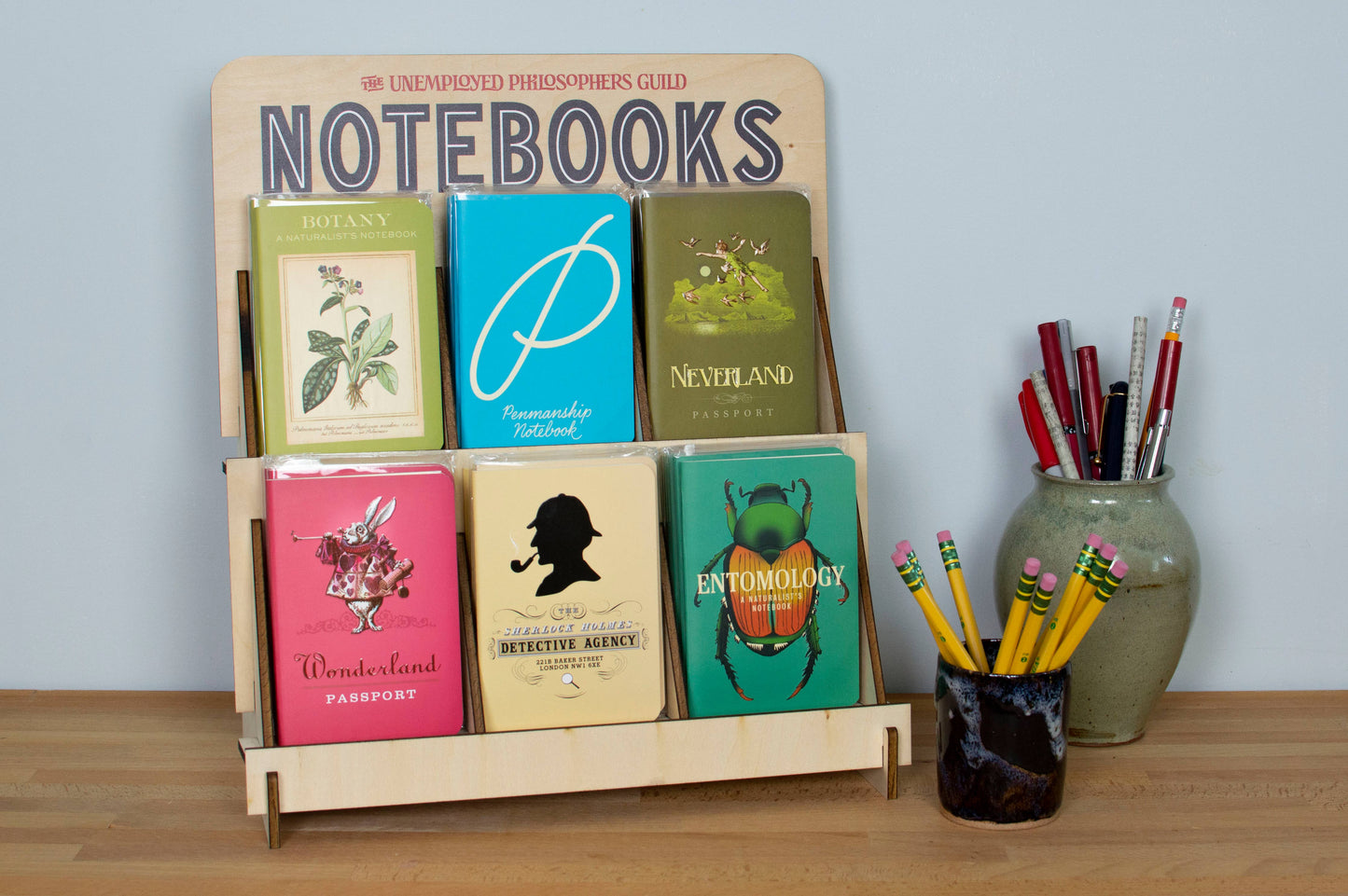 Display of colorful penmanship notebooks at a stationery store with pencils and pens, 48-page pocket-sized options for practice.