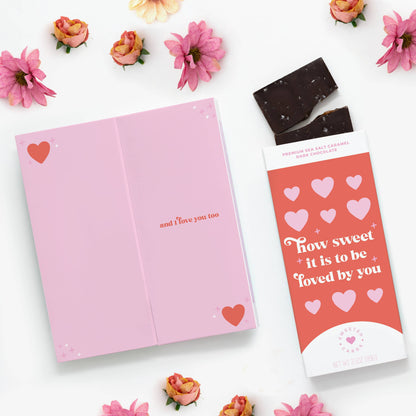 Open pink chocolate greeting card with sea salt caramel dark chocolate bar, featuring 'How Sweet It Is to Be Loved By You.' Stationery store.