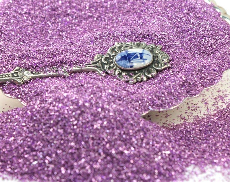 Lilac sparkly German glass glitter 90 grit with vintage silver spoon, stationery store supplies for crafts and decoration.