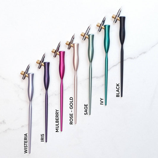 Flourish Calligraphy Pen set in Wisteria, Iris, Mulberry, Rose Gold, Sage, Ivy, Black colors, perfect for artistic writing; available at stationery stores.