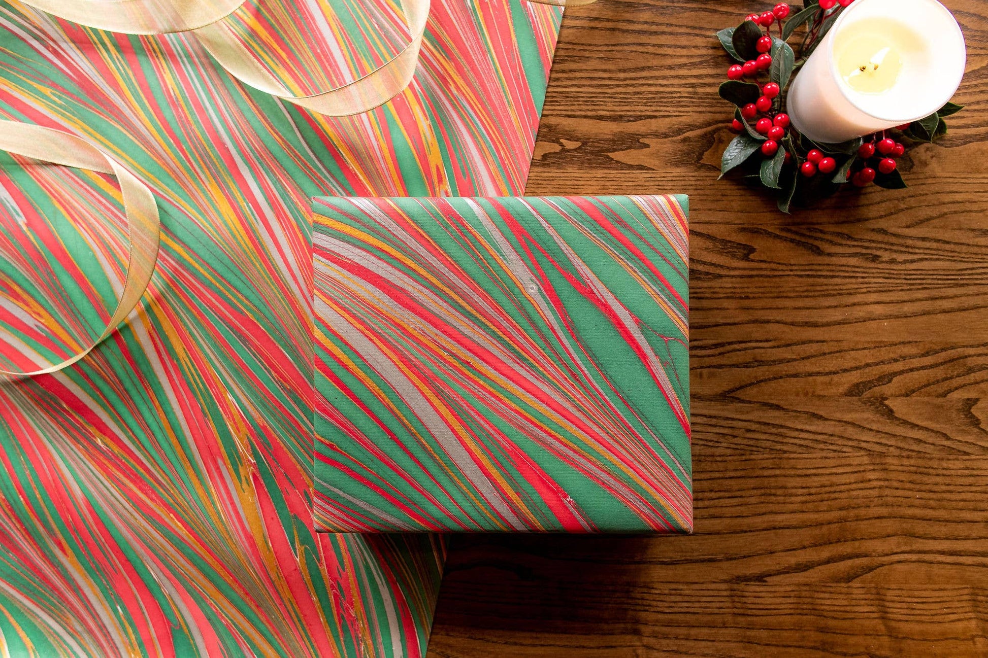 Hand marbled Christmas wrapping paper with striations design displayed on a table, perfect for festive gifts, art, and craft projects.