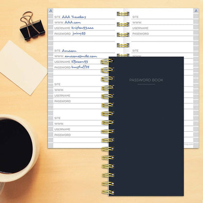 Black spiral password book on desk, ideal for organizing login info, with lined pages for websites, usernames, and passwords. Stationery store.