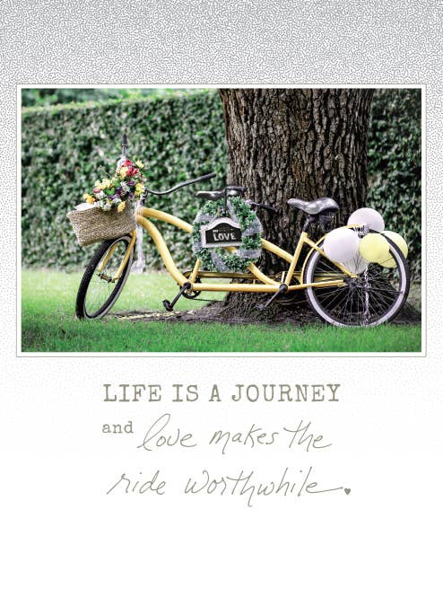 Yellow bike with flowers and balloons, captioned 'Life is a journey, love makes the ride worthwhile,' from a stationery store card.