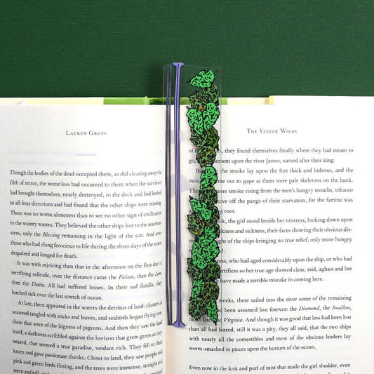 Baggie of Weed Bookmark in use, die-cut lexan, flexible and durable, poking out from book pages. Ideal for stationery store offerings.