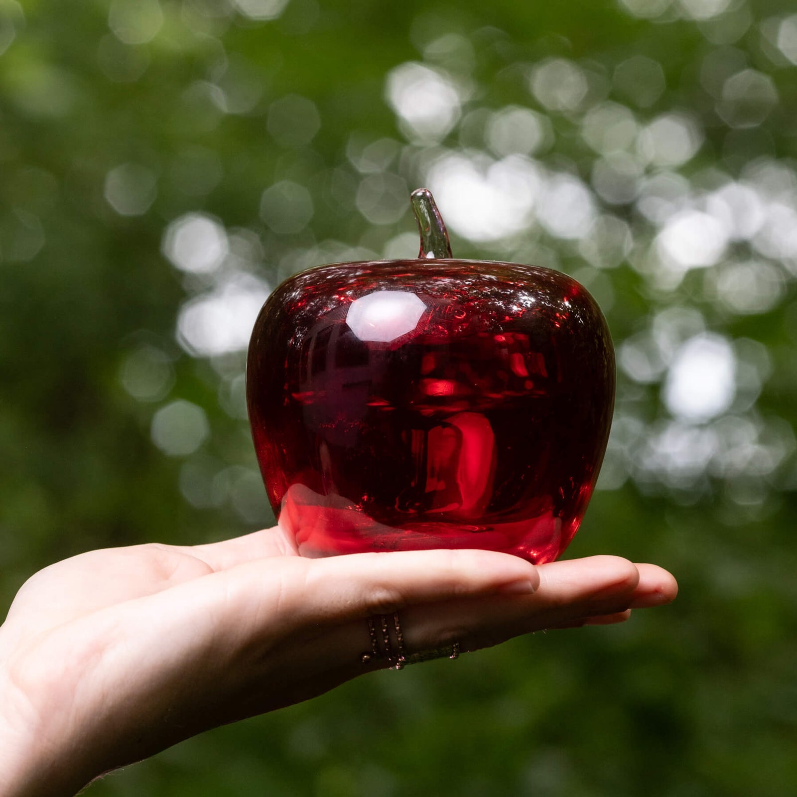 Blenko Red Apple Paperweight held in hand, perfect for stationery stores; unique, high-quality glass decor.