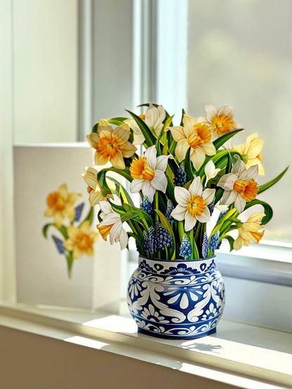 Mini English Daffodil pop-up bouquet with grape hyacinth in a paper vase, perfect for a gift from a stationery store.