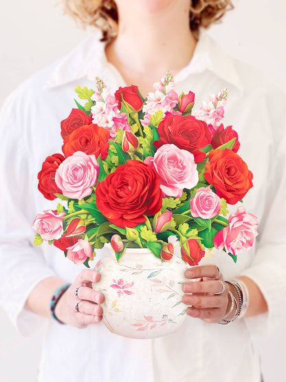 Blooming Roses Pop Up Greeting Card with pink and red flowers in a watercolor vase, featured in a stationery store.