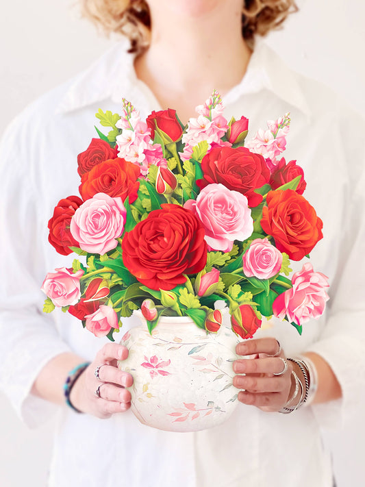 Blooming Roses Pop Up Greeting Card with pink and red flowers in a watercolor vase, featured in a stationery store.