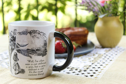 Cheshire Cat Heat-Changing Coffee Mug featuring Wonderland scene, ideal for coffee or tea, available at stationery stores.