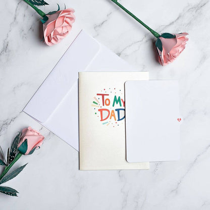 To My Dad 5x7 Pop-Up Father's Day Card with colorful design, displayed with pink roses on a marble surface, available at stationery store.