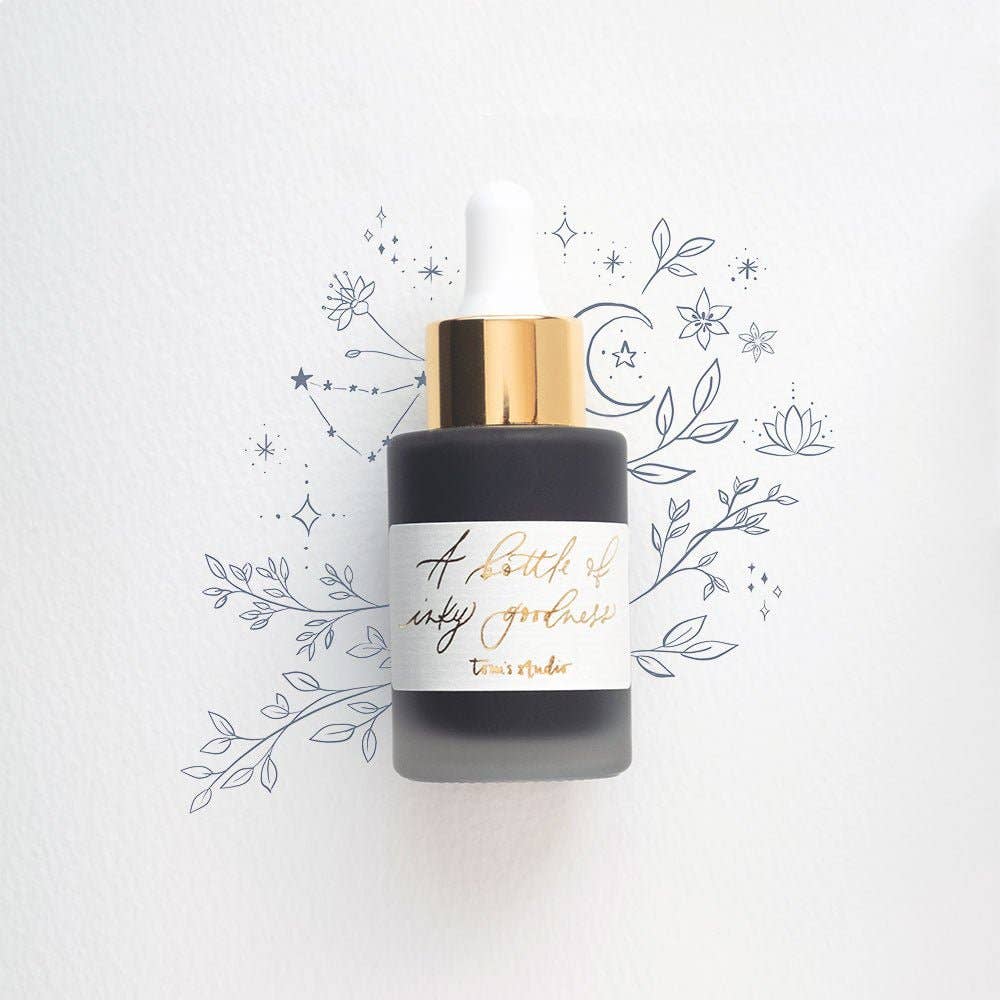 Moon Grey Calligraphy Ink bottle with gold foil label, 30ml, shown with floral illustration backdrop, available at stationery store.