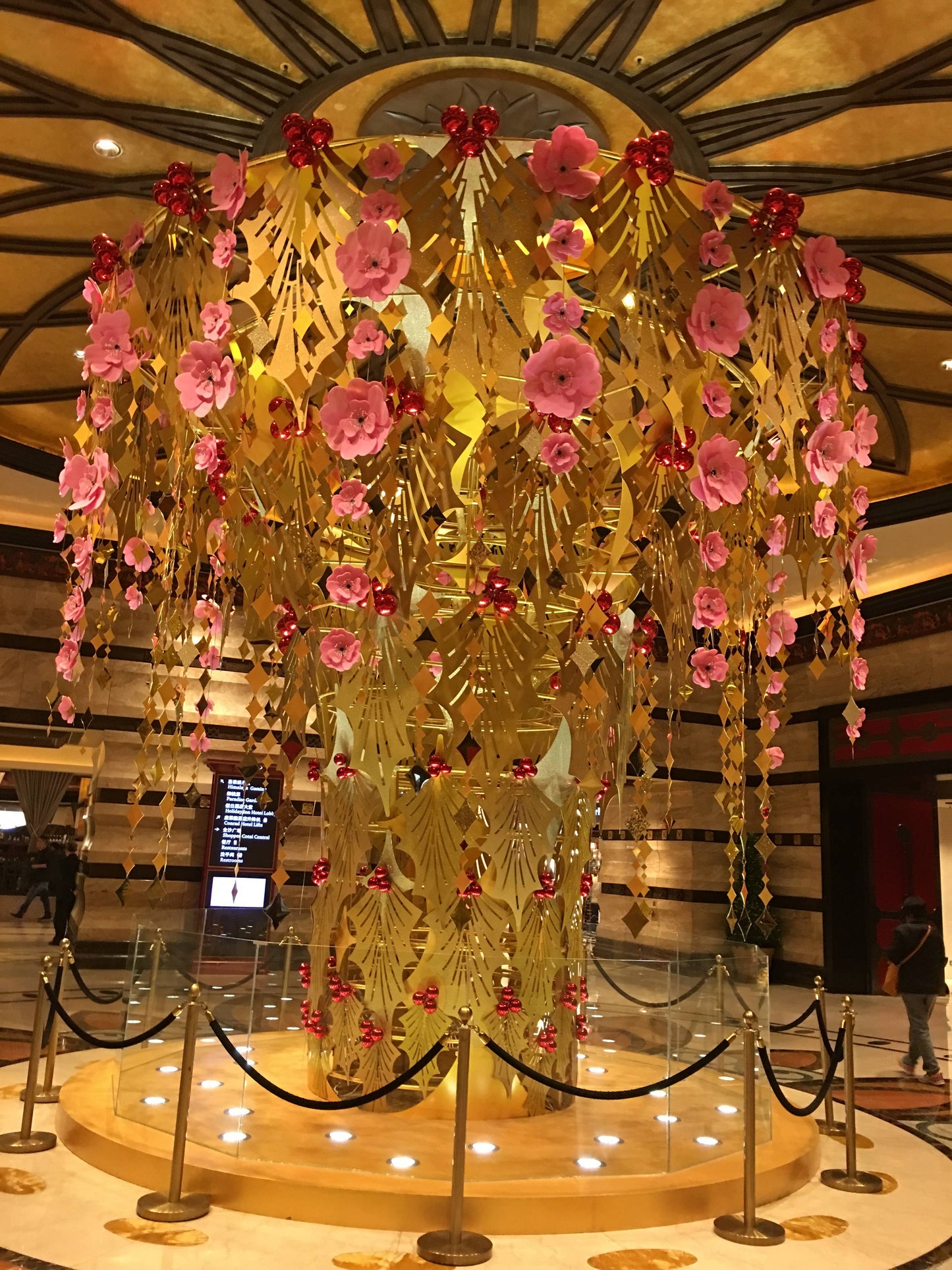 Elegant display of pink and gold hanging floral arrangement in a luxurious setting at a stationery store.