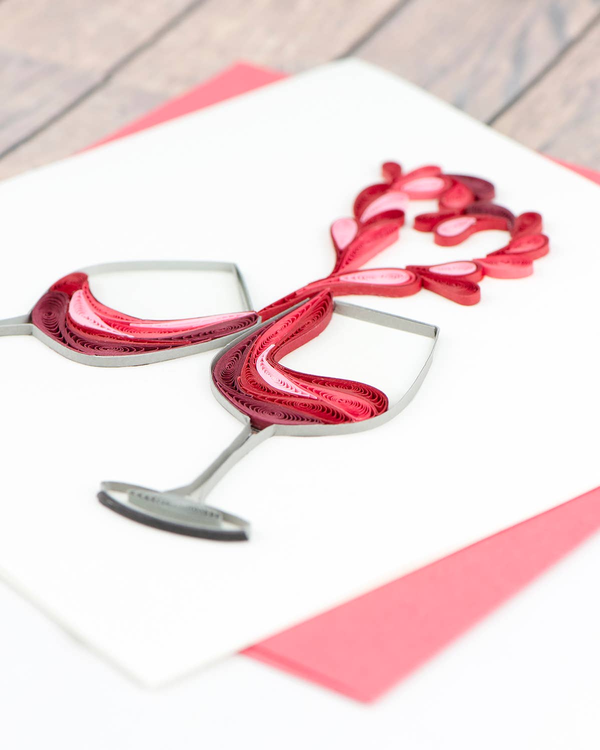 Quilled greeting card featuring wine glasses forming a heart, A Toast to Love, from a stationery store. Perfect for expressing affection.