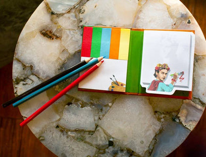 Frida Reflections Sticky Notes with pencils on a table, available at stationery stores, features colorful page markers and Frida art.