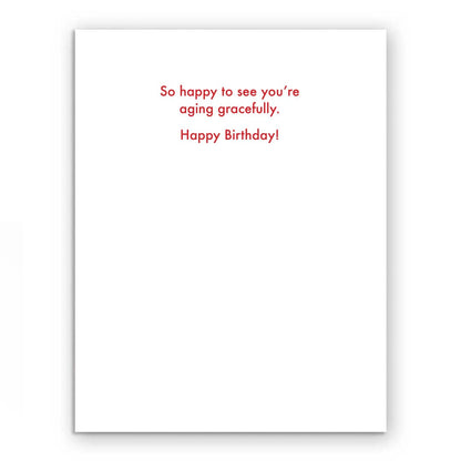 Aging Gracefully Doll Birthday Card with red text: 'So happy to see you're aging gracefully. Happy Birthday!' Ideal for stationery stores.