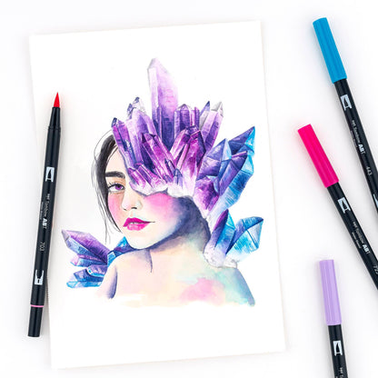 Art created with Dual Brush Pen Art Markers in Galaxy colors, featuring a woman's face with purple crystals, available at stationery stores.