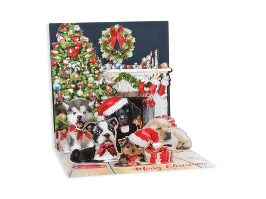 Christmas Puppies Pop-Up Card with festive tree and fireplace, available at stationery store. Includes Merry Christmas greeting and glitter accents.