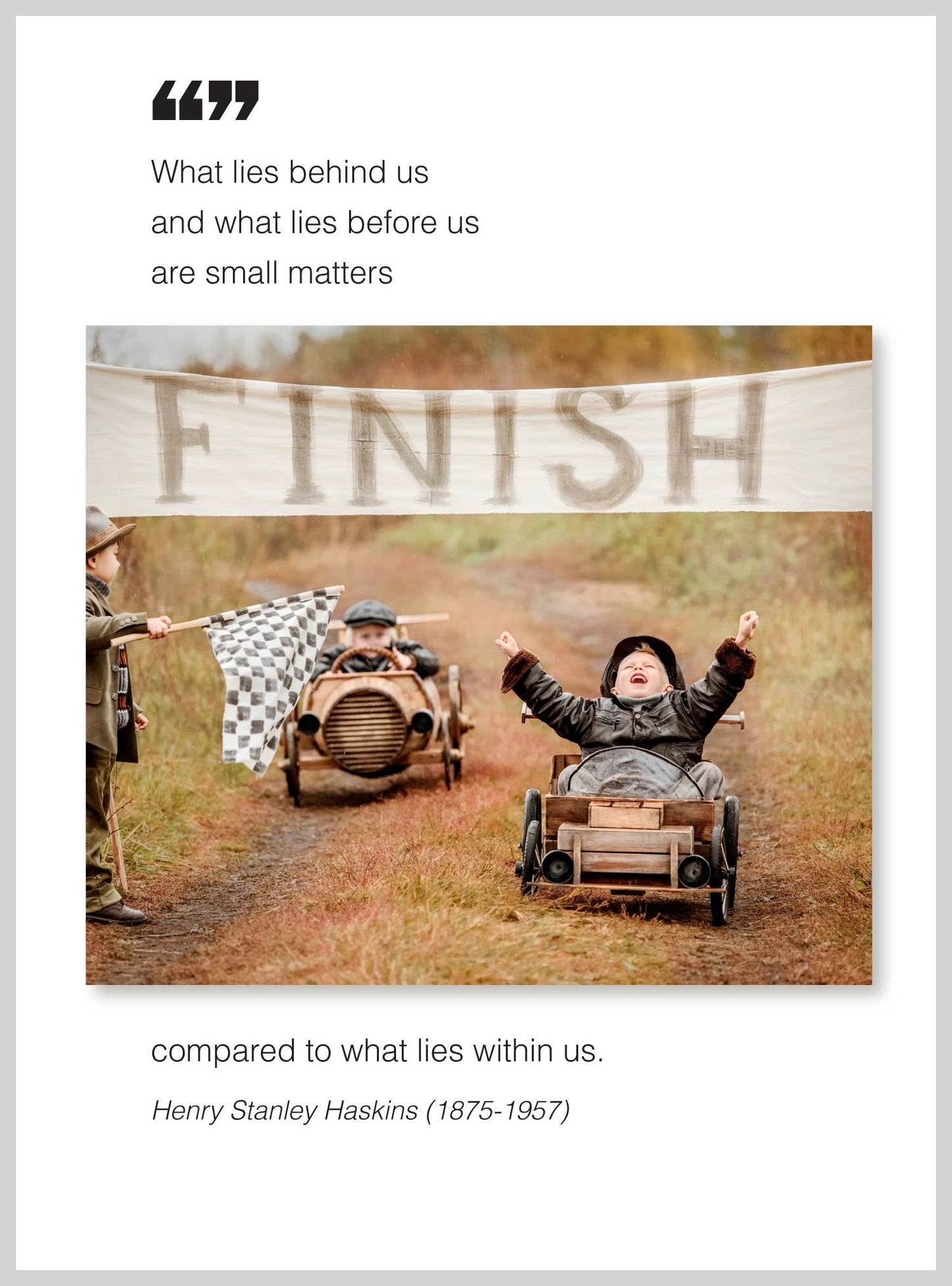 Children racing in toy cars at a finish line under a motivational quote about inner strength by Henry Stanley Haskins.