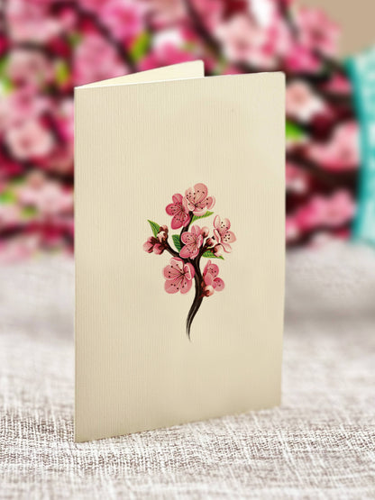 Mini Cherry Blossom Pop-up Greeting Card at stationery store, featuring pink blossoms on a blank notecard with vibrant floral design.