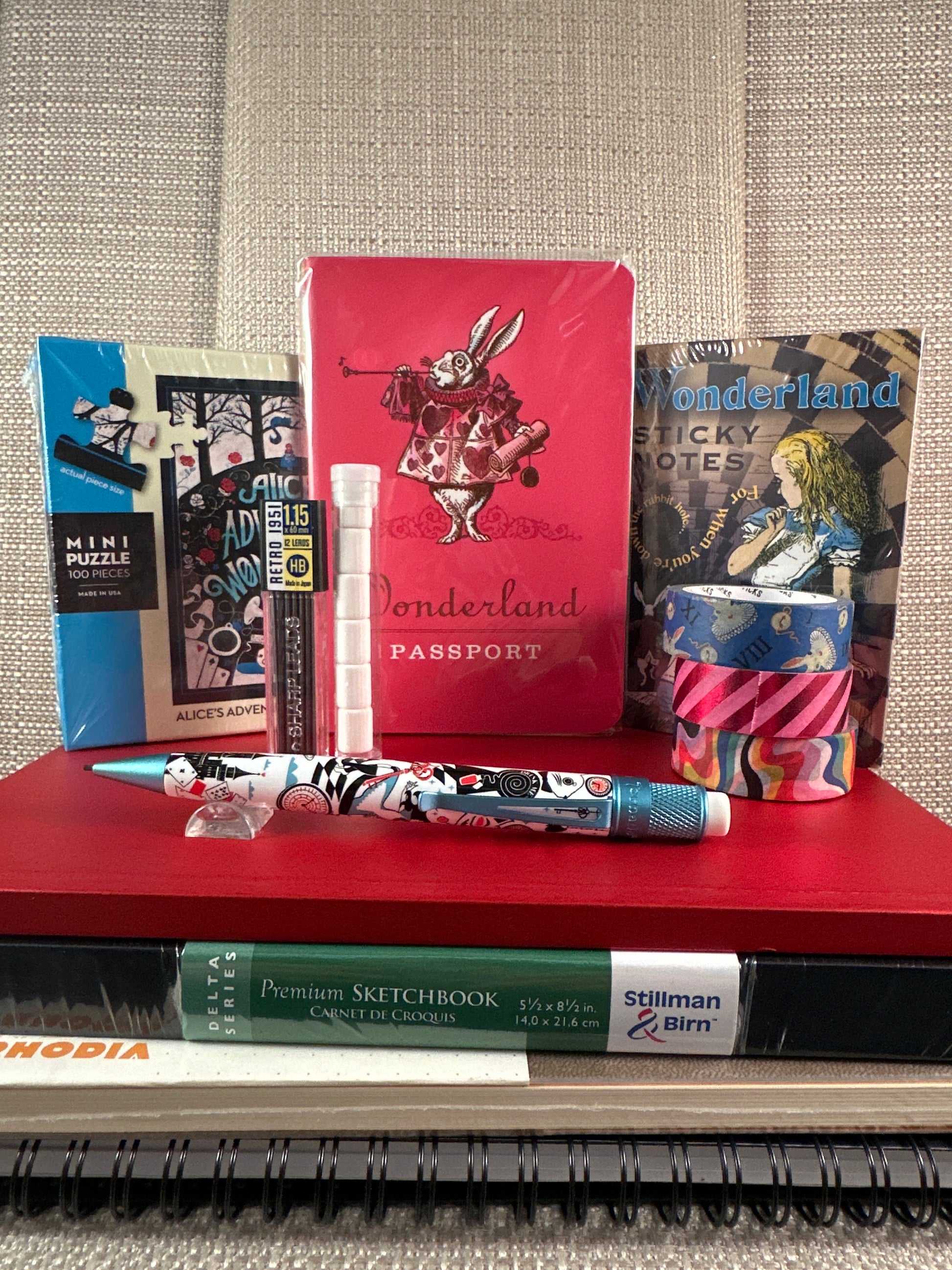 Alice in Wonderland-themed stationery set with notebooks and pens from a stationery store.