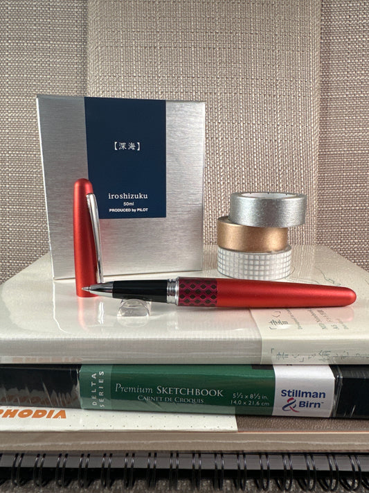 Pilot Metropolitan Rollerball Pen in red with stationery items including tape and sketchbooks for elegant writing in a stationery store.