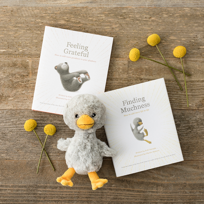 Plush Duckling with motivational books at stationery store, unique high-quality gift option on wooden table.