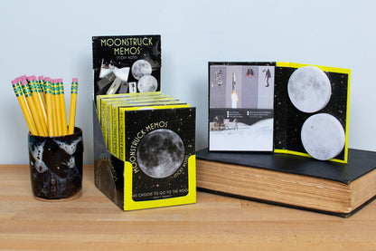 Moonstruck Memos Sticky Notes on display in stationery store, featuring moon-inspired designs and vibrant pencils nearby.