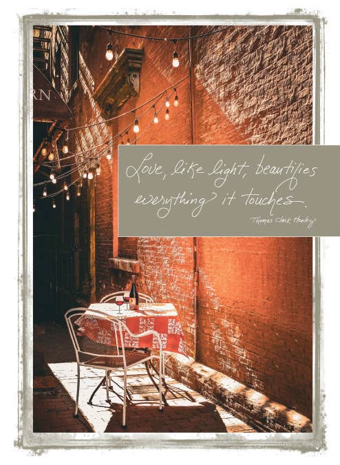 655W card with quote 'Love, like light, beautifies everything it touches' featuring cozy, lit outdoor setting. Available at stationery store.