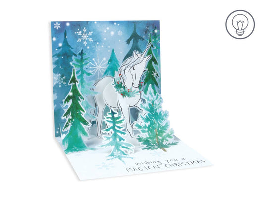 Magical Christmas Unicorn Pop-Up Card with snowy forest design, featuring festive artwork and wishing message. Perfect for stationery store collection.