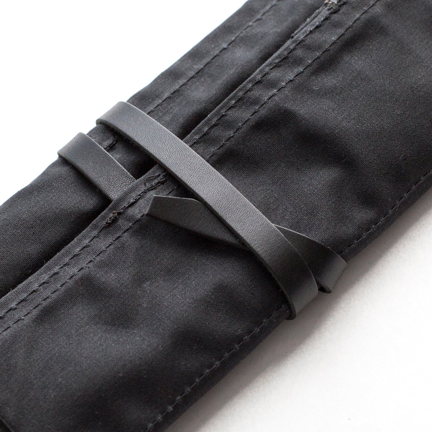 Blackwing Pencil Case in black canvas from stationery store; shown rolled and secured with strap.