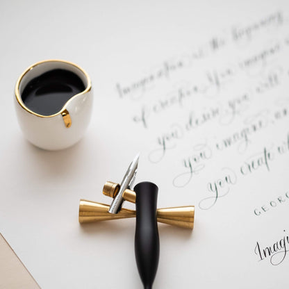 Flourish Calligraphy Pen with ink and artistic script, ideal for elegant writing. Perfect for stationery store enthusiasts.