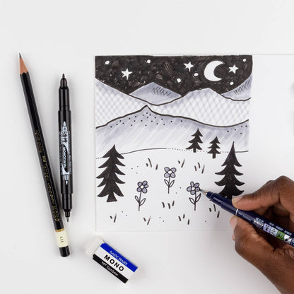 Tombow Drawing Set from stationery store used for creating a black and white doodle of mountains and trees. Contains brush pens and eraser.