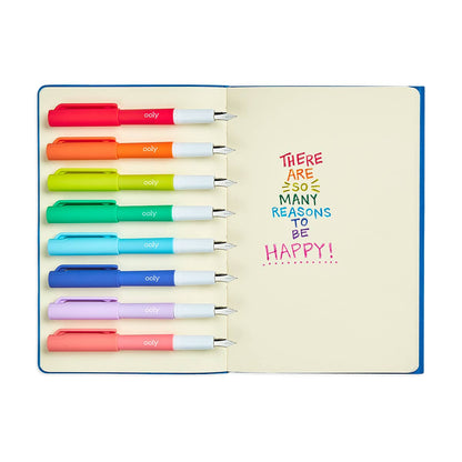 An open notebook displaying OOLY Color Write Fountain Pens in 8 vibrant colors, ideal for stationery stores and creative writing.