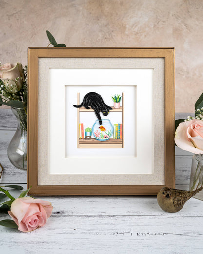 Quilled Mischievous Cat Greeting Card with black cat dipping paw in fish bowl, framed on wooden table. Perfect for stationery store collection.