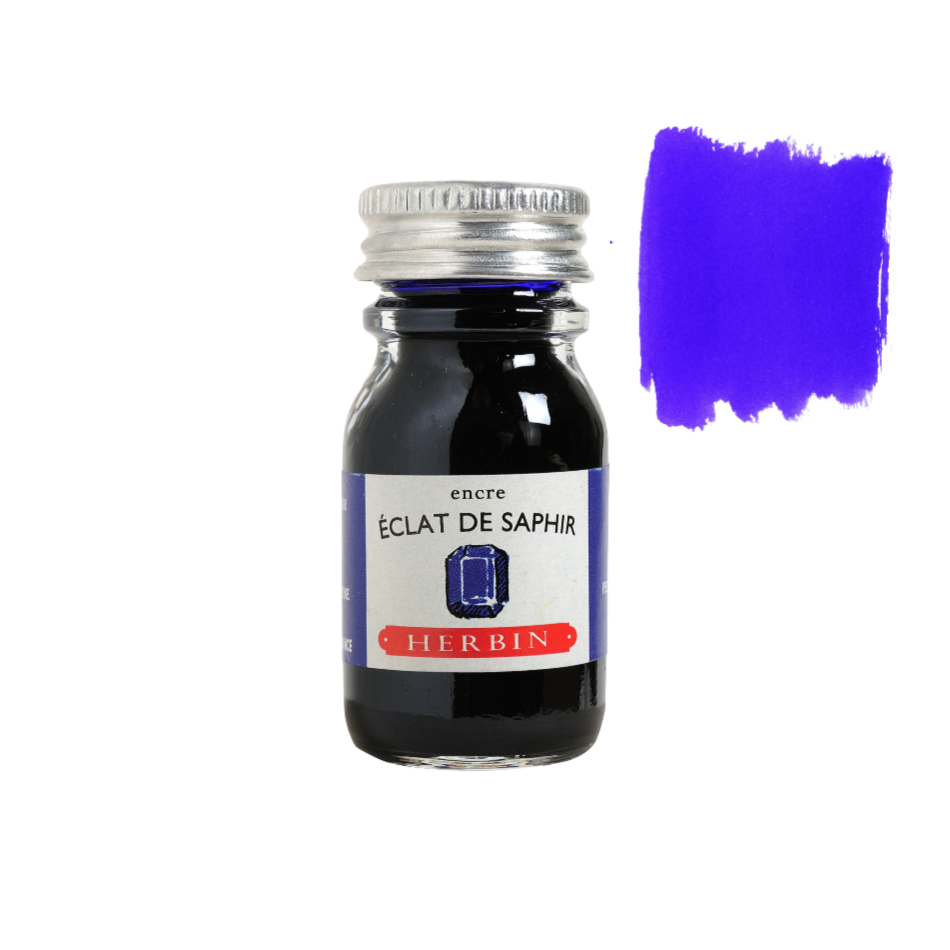 Close-up of a hand holding a Herbin Bleu Pervenche fountain pen ink 10ml bottle, elegant stationery from Paris, available in 35 colors