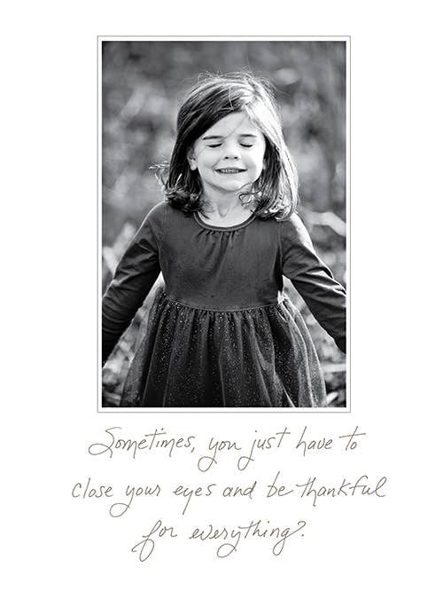 Black and white photo of a joyful girl with 'Sometimes, You Just Have to Close Your Eyes and Be Thankful' quote, from Bonair Daydreams card, stationery store item.