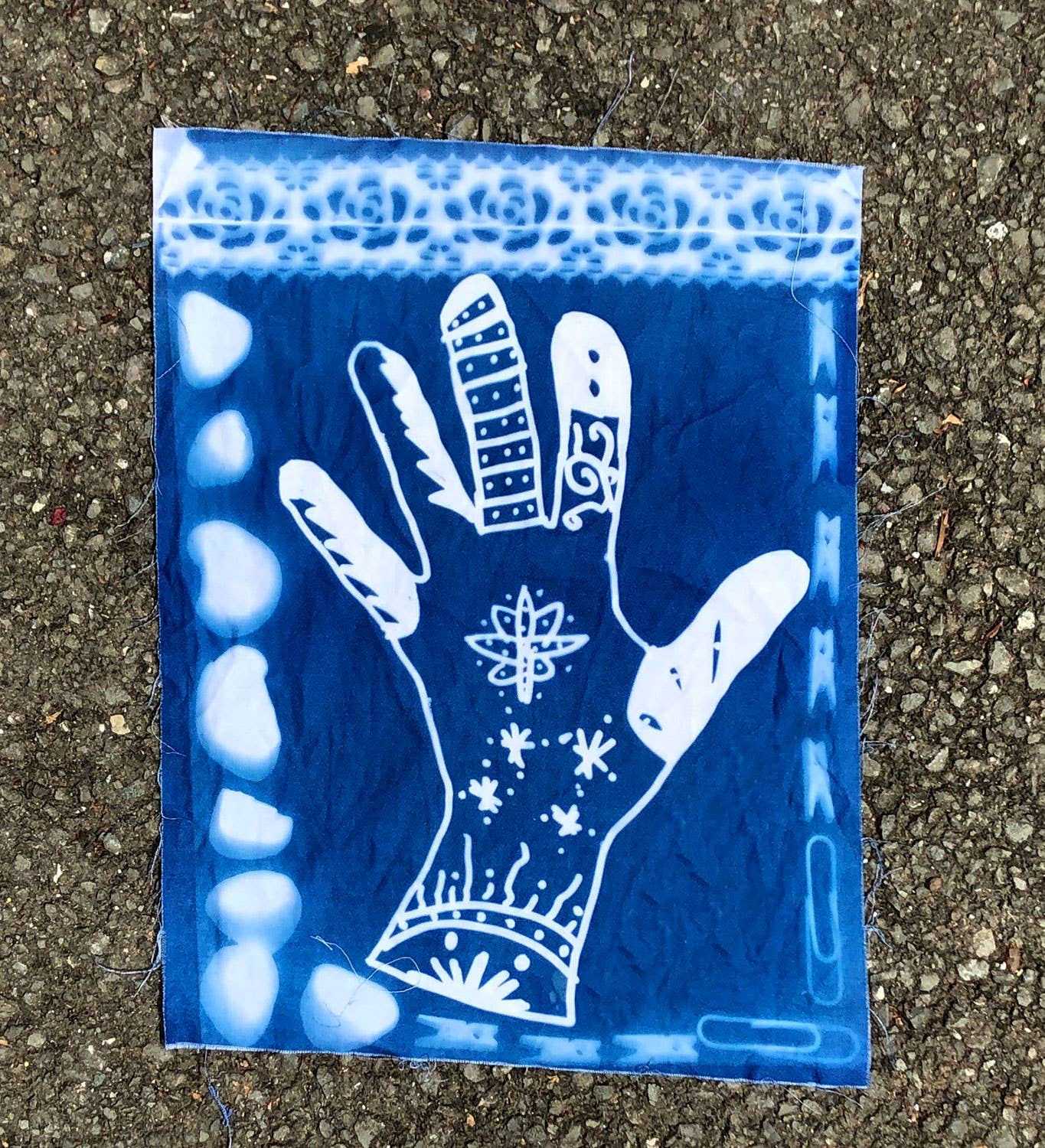 Hand design on cyanotype fabric sheet from Jacquard's 10-Pack for sun printing, available at stationery stores.