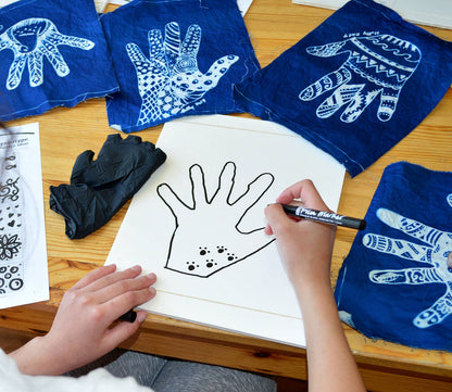 Person drawing designs on Cyanotype Fabric Sheets from a 10-Pack, showcasing antique photographic printing at a stationery store.