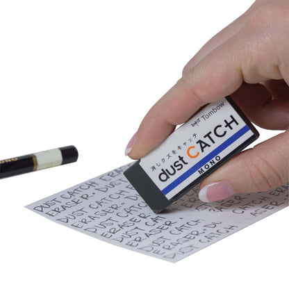 Hand using MONO Dust Catch Eraser to remove markings, with eraser dust sticking to it; perfect for stationery store needs and clean illustrations.