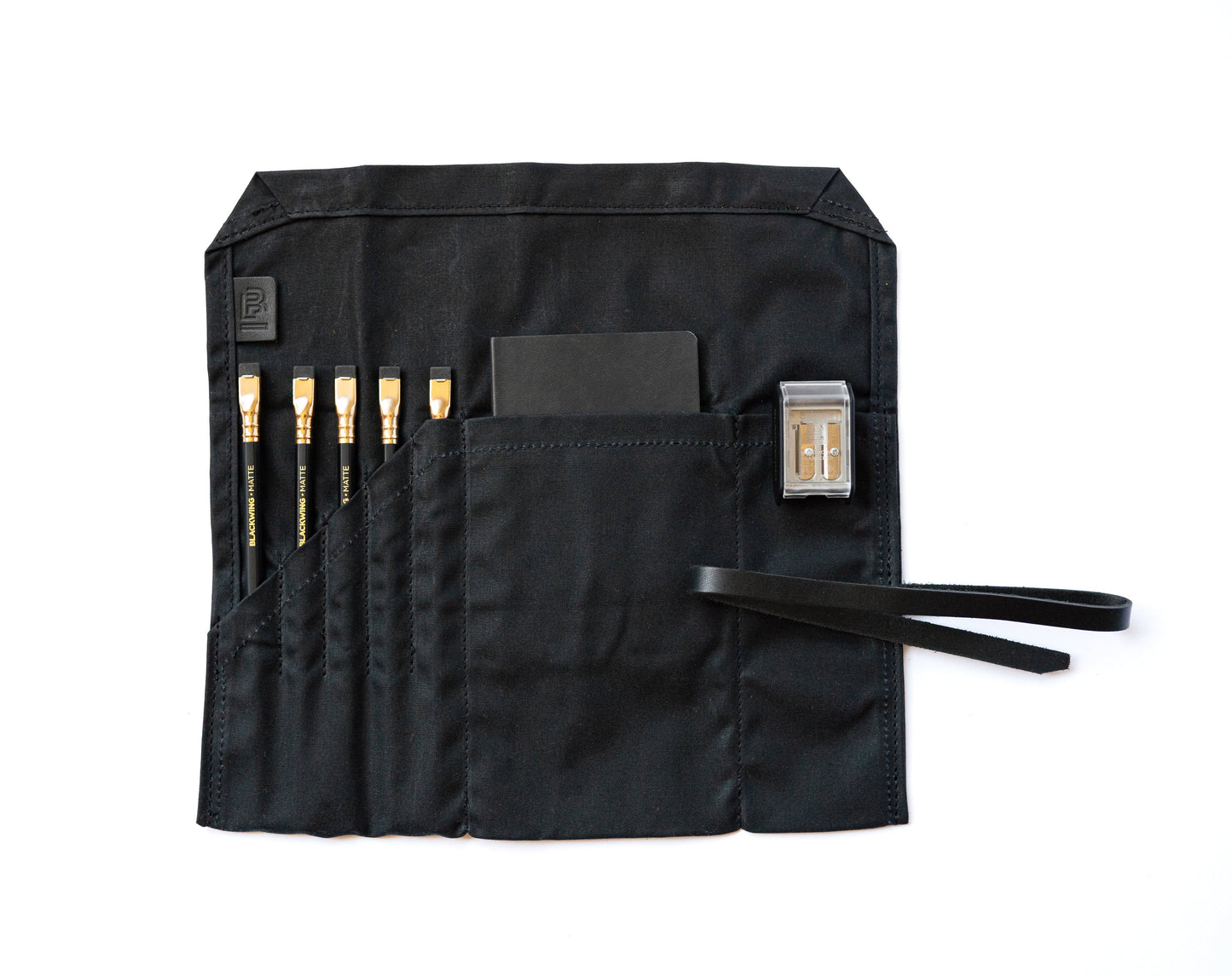 Blackwing Pencil Case in black canvas with pencils and sharpener, available at stationery store. Perfect for organizing writing tools.